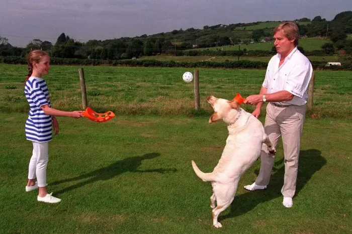 Framed Print : William Roache Actor playing with his daughter and their dog in the back garden Framed Print : William Roache Actor playing with his daughter and their dog in the back garden