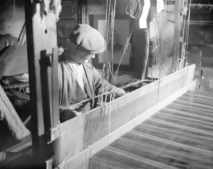 Framed Print : Willie Meisle using a loom to weave a tartan. Circa 1930