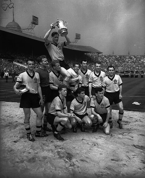 Wolves captain Bill Slater carried on the shoulders of his team with FA cup trophy after