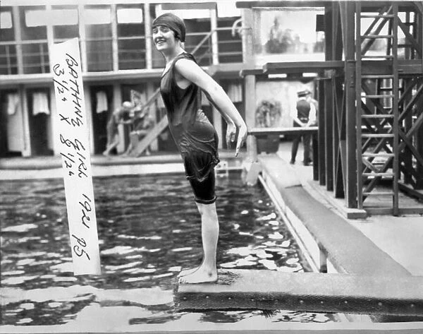 Woman in a 1920s style swimming costume about to dive in to a swimming pool