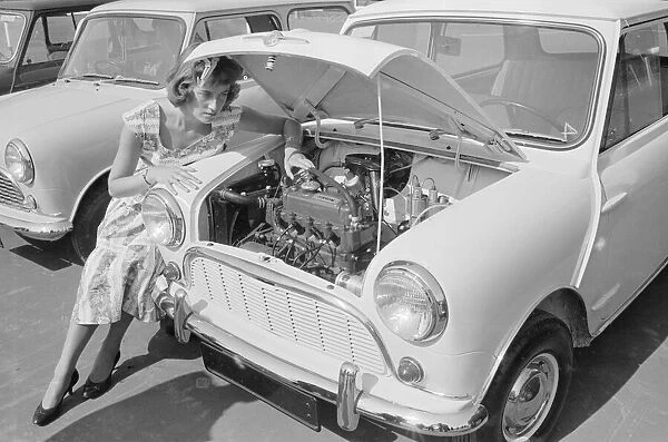 A woman checks the engine of one of the first mini cars designed by Alec Issigonis which