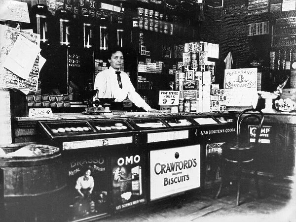 A woman behind the counter of a general store. Cambridge, Cambridgeshire. Circa 1920