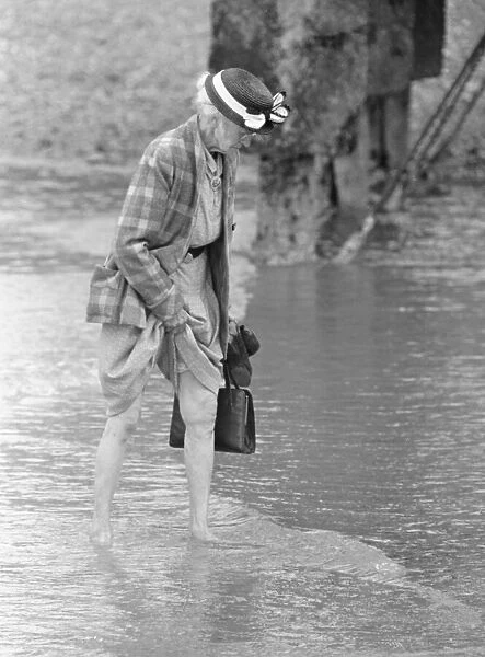 A woman goes for a paddle in the sea on the beach at Brighton July 1958