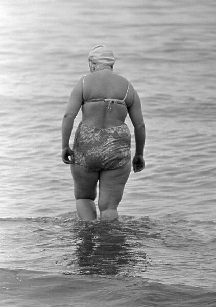 A woman goes for a swim in the sea on the beach at Brighton July 1958
