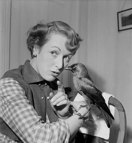 Woman holding a bird on her arm. November 1952 C5808-006