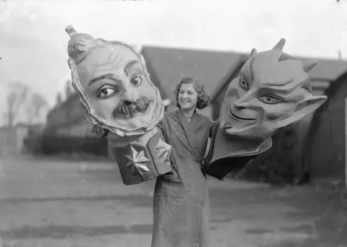 Framed Print : Woman holding two giant masks of the devil at the Twickenham Garden Fete. Circa 1930 Framed Print : Woman holding two giant masks of the devil at the Twickenham Garden Fete. Circa 1930