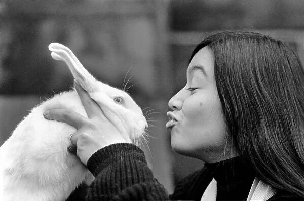 A woman holding a rabbit close to her face. December 1969 Z11963