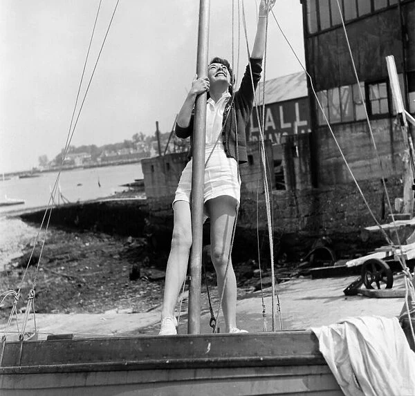 Woman inspect the rigging of her dinghy in preparation for the Isle of Wight Yacht Race