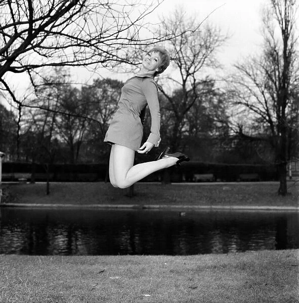 Woman jumping up in the air, smiling wearing mini dress. November 1969 Z11409-001