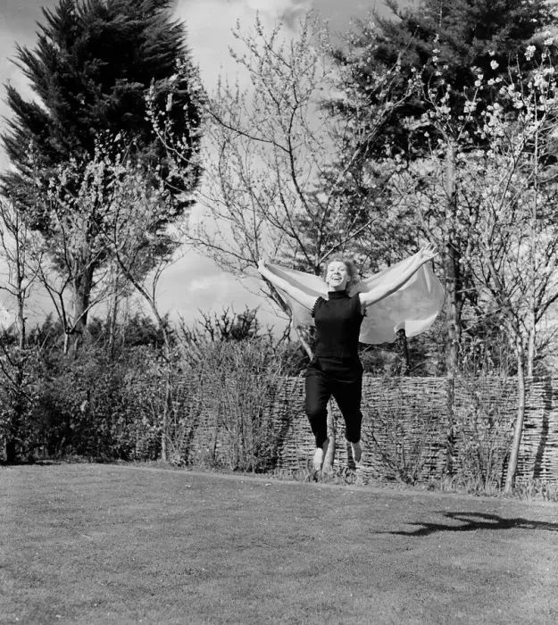 Framed Print : A woman jumping up and down in her back garden on a pleasant Spring day Circa 1954