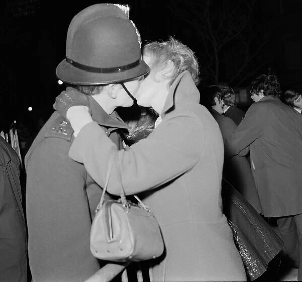 A woman kisses a policemen to celebrate New Year in Albert Square, Manchester