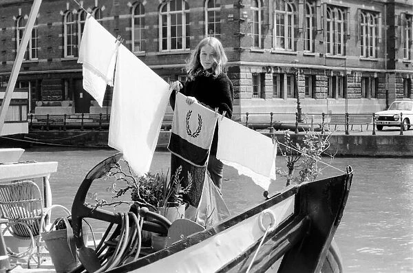 A woman living on a boat in Rotterdam, hanging her laundry on the washing line on board
