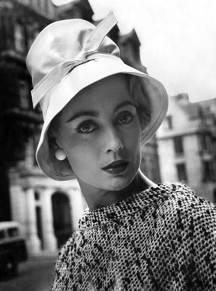 A woman modelling a fashionable hat. July 1957