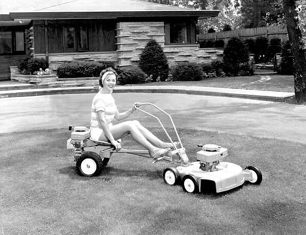 Woman mowing the lawn, smiling Sit down lawnmower January 1962
