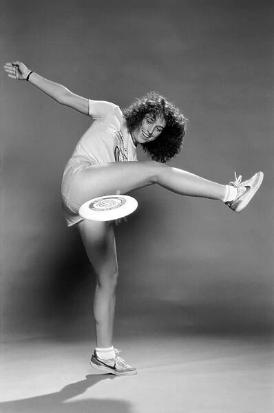 A woman performing exercises with a frisbee. June 1980