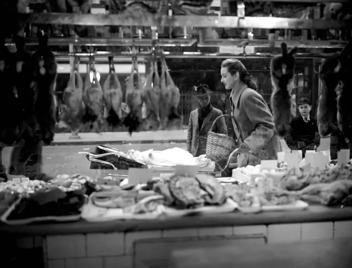 Framed Print : Woman pictured pushing pram as she passes by a butchers shop window March 1952