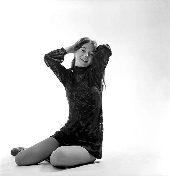 Woman poses in the studio wearing a black mini dress. December 1969 Z11850