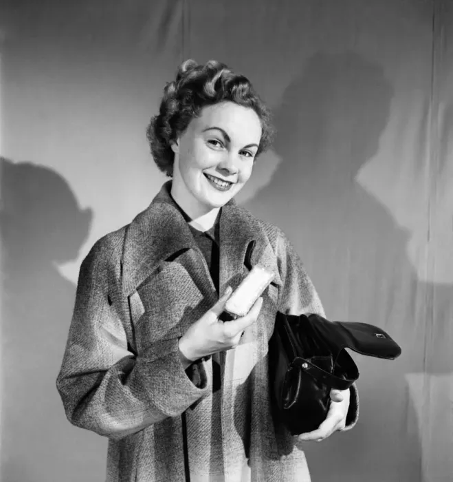 Framed Print : Woman poses wearing a long coat and holding a handbag. October 1952 C6273 Framed Print : Woman poses wearing a long coat and holding a handbag. October 1952 C6273