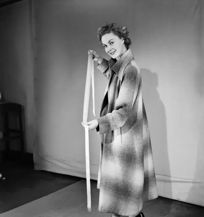 Framed Print : Woman poses wearing a long coat and holding a head scarf Framed Print : Woman poses wearing a long coat and holding a head scarf