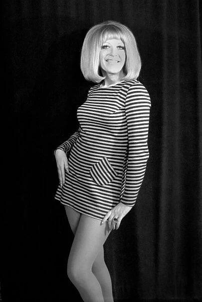 A woman posing for photographs wearing a striped mini dress