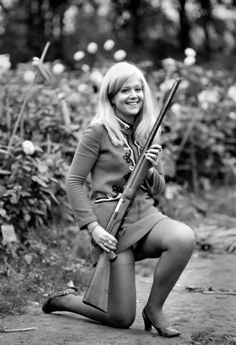 Framed Print : A woman posing wearing a mini dress and holding a shot gun November 1969 Framed Print : A woman posing wearing a mini dress and holding a shot gun November 1969