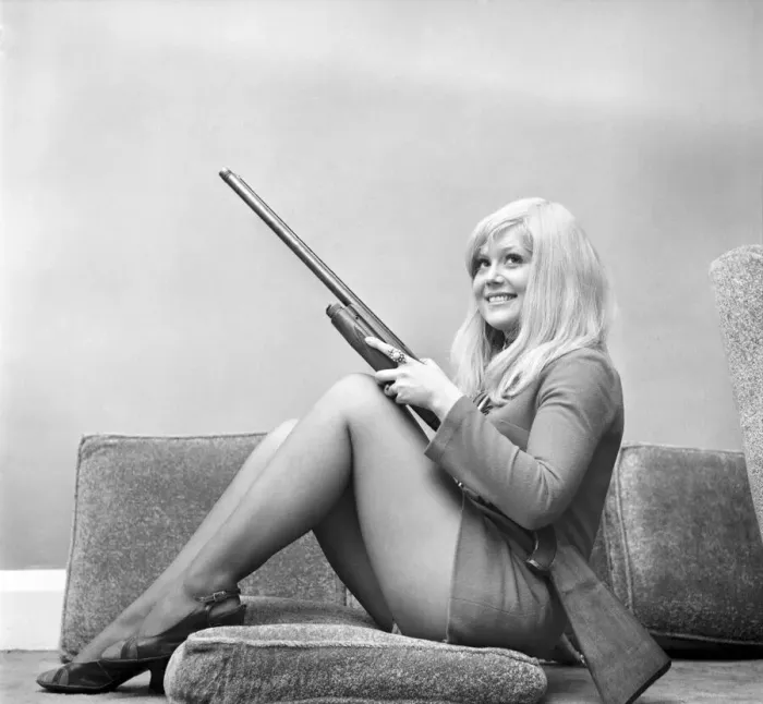 Framed Print : A woman posing wearing a mini dress and holding a shot gun November 1969 Framed Print : A woman posing wearing a mini dress and holding a shot gun November 1969