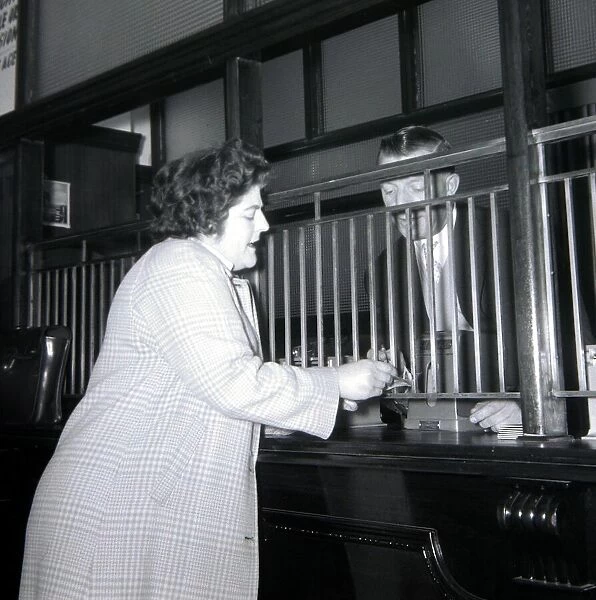 A woman punter hands over the money to cover her bet at A E Fane