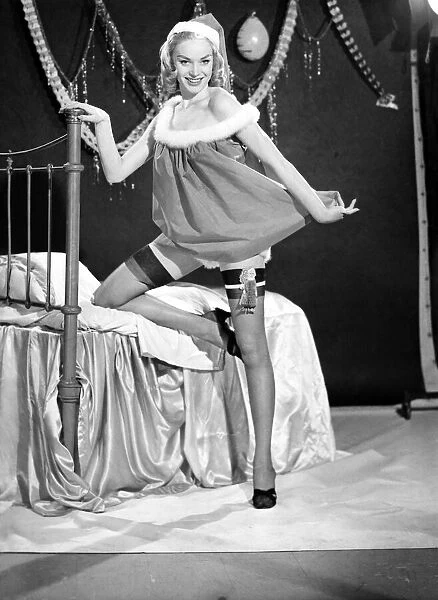 Woman putting up her Christmas stocking. 1959 E368-002