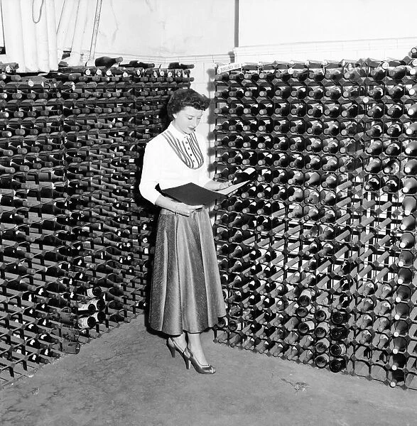 Woman seen here inspecting wine bottles. 1957 A17-002