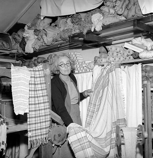 Woman seen here with rolls of material she has woven with her loom. 1955