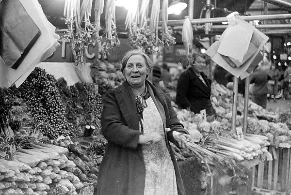 Woman serving on the green grocers stall at Kingston Market. Circa 1936