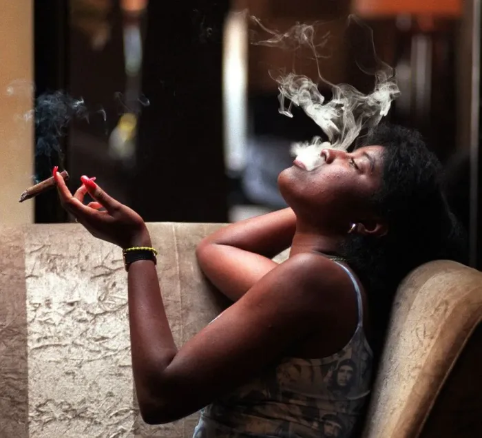Framed Print : A woman sitting at a table smoking a cigar August 1998