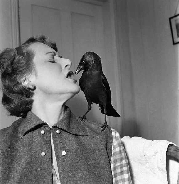 Woman talking to a bird perched on her shoulder. November 1952 C5808-003