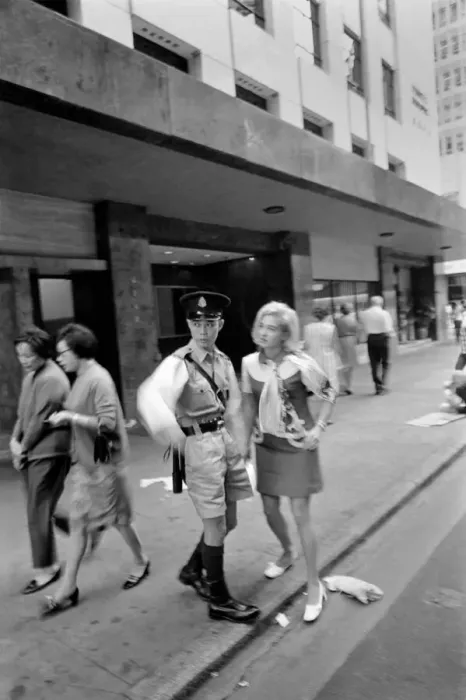 Framed Print : Woman on a visit to Hong Kong for a shopping trip asks a policeman for directions Framed Print : Woman on a visit to Hong Kong for a shopping trip asks a policeman for directions