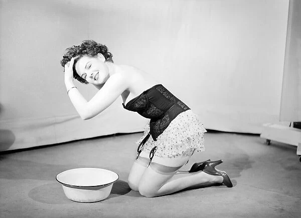 Woman wearing corsett washing hair. 1959