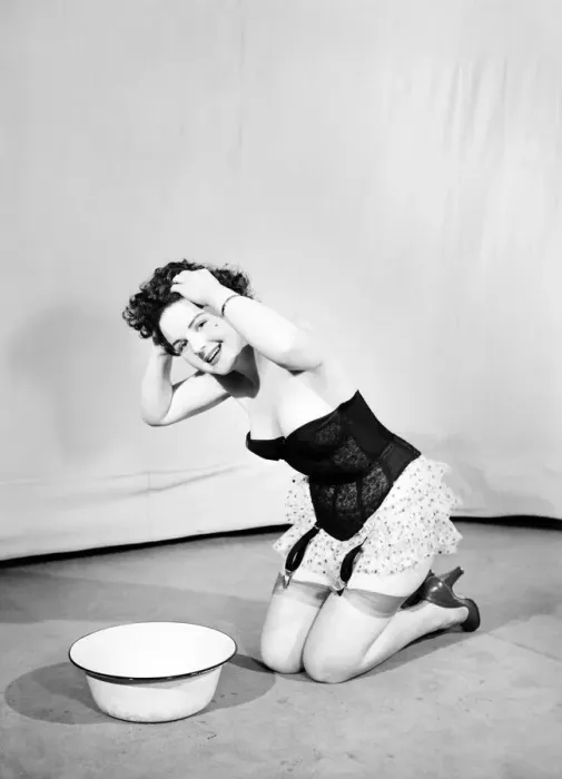 Framed Print : Woman wearing corsett washing hair. 1959