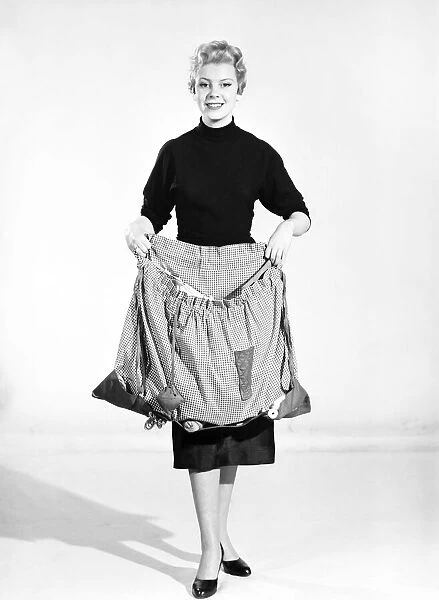 Woman wearing Dutch apron that converts into a bag. 1955
