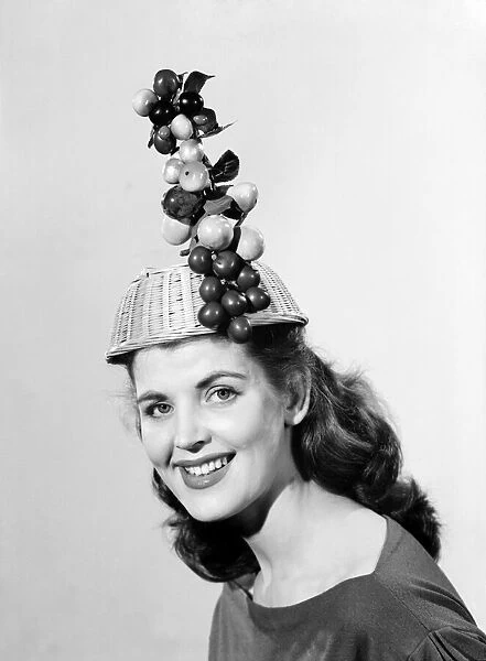 Woman wearing fruit basket hat. 1957