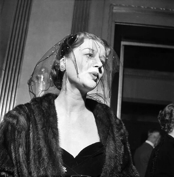 Woman wearing a fur coat and veil at a cocktail Party. November 1952 C6295