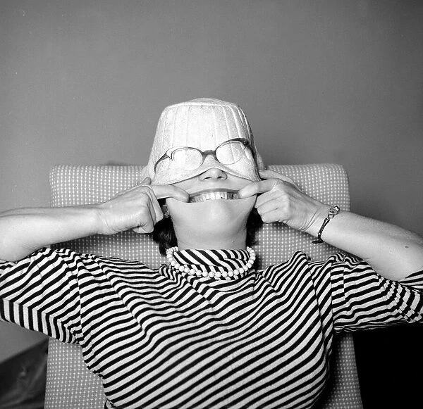 A woman wearing a hat over her face with glasses on top