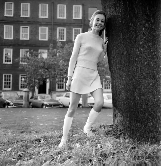 Framed Print : Woman wearing matching top, mini skirt and knee high looks poses for pictures Framed Print : Woman wearing matching top, mini skirt and knee high looks poses for pictures