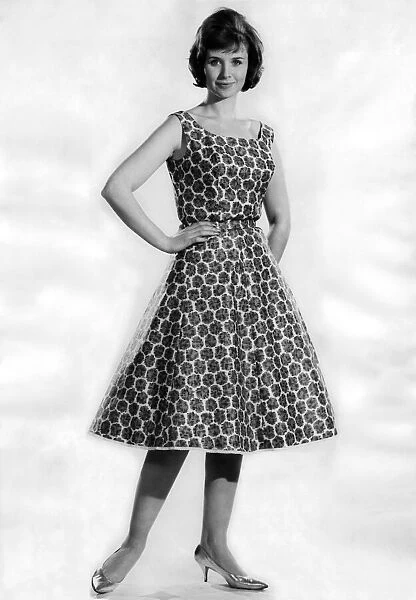 Woman wearing a patterned flared dress. May 1962 P011064