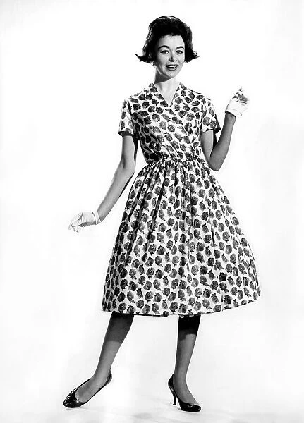 Woman wearing a patterned long dress with gloves March 1960 P009011