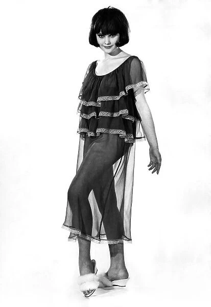 Woman wearing short sleeved see through top with leg warmers July 1963 P009020