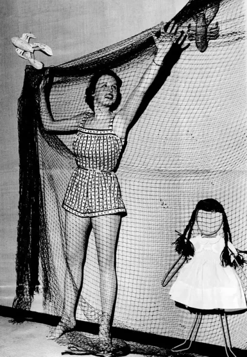 Framed Print : Woman wearing a short summer dress hangimg up netting November 1953 P017640