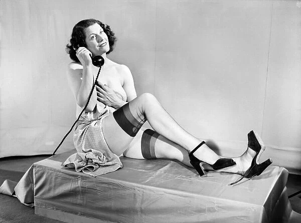 Woman wearing stockings seen here on the telephone. 1959