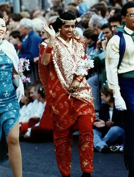 A woman wearing traditional Indian clothing waves to the camera at the 1991 Edinburgh
