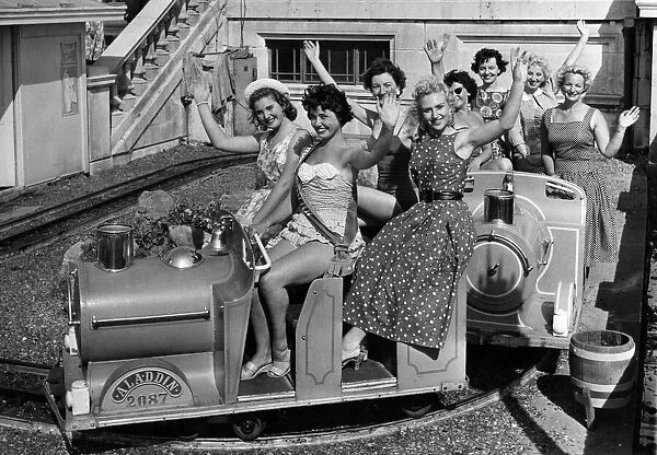 Women: Beauty contest. Contestants in the Mirror Beach Fashion Show ride the fairground