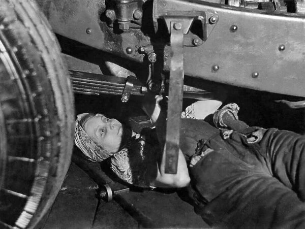 A women bus mechanic at work underneath the vehicle. June 1941 P010117