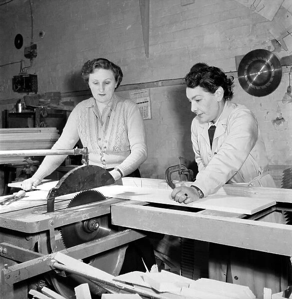 Women carpenters constructing an ironing board in a workshop. 1954 A95-003